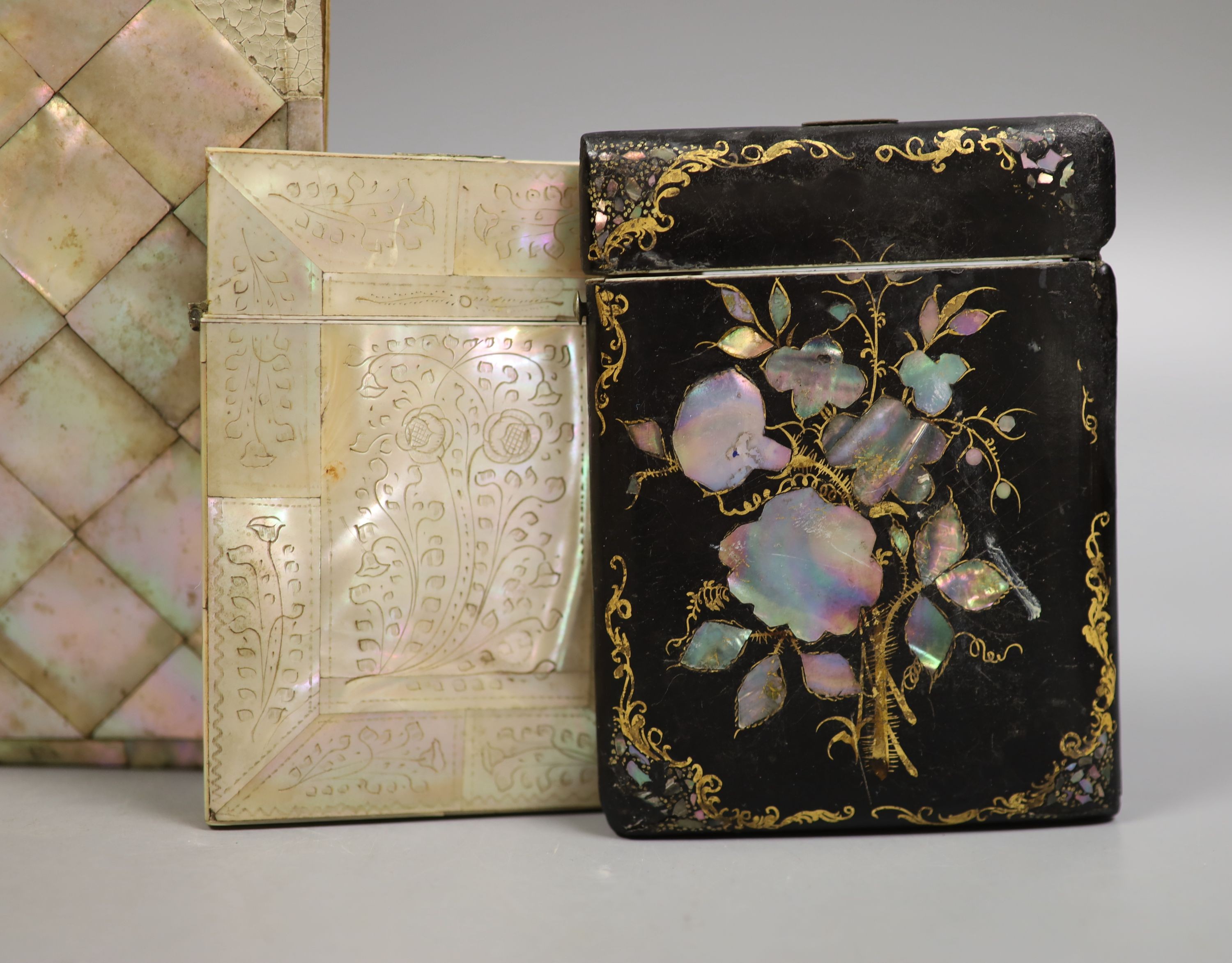 Three Victorian mother of pearl card cases, a papier mache card case and a mother of pearl bound book